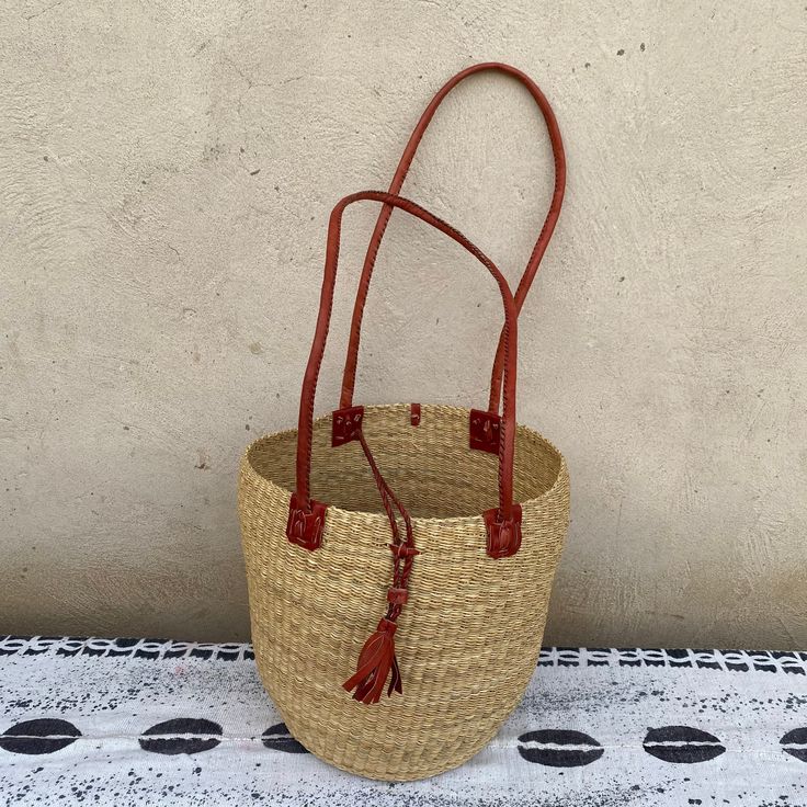 Brown Straw Bag With Bamboo Handle In Bucket Shape, Brown Bamboo Handle Straw Bucket Bag, Bohemian Natural Bucket Shoulder Bag, Bohemian Natural Color Bucket Shoulder Bag, Natural Straw Bag Fair Trade, Brown Handwoven Jute Bucket Bag, Natural Straw Fair Trade Bag, Straw Bucket Bag For Market, Natural Fiber Bucket Bag With Bamboo Handle