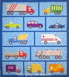 a quilted wall hanging with cars and trucks on it's blue backings