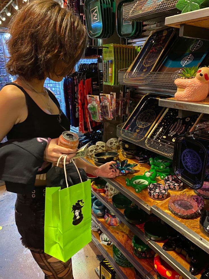 a woman is shopping in a store with her hand on the bag and looking at items