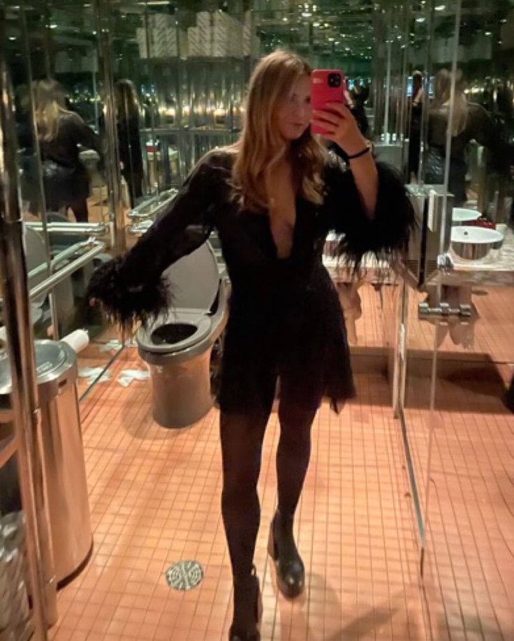 a woman taking a selfie in front of a mirror