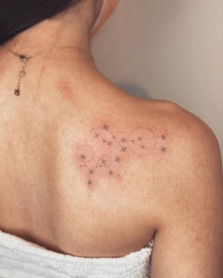 the back of a woman's shoulder with small stars on her left arm and chest