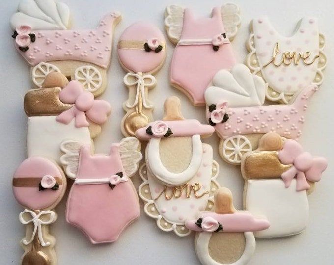 decorated cookies are arranged in the shape of baby items