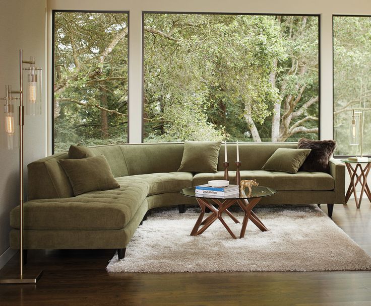 a living room filled with furniture and large windows