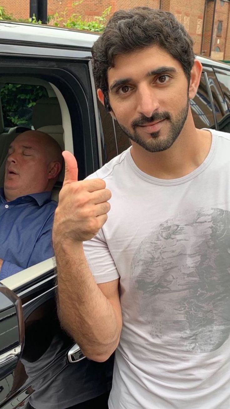 a man giving the thumbs up in front of his car