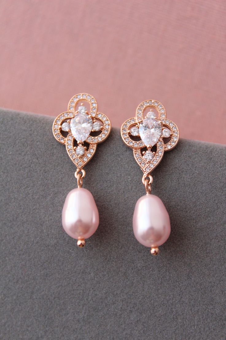 Vintage style  earrings with pink  pearls.    Pink Wedding jewelry Prom earrings  GREAT for brides or bridesmaids/prom Color:  -rhodium-silver tone/clear rosaline pink pearl ( NOTE: leave message at check out if you prefer with white/lt.ivory pearls) -or yellow gold/clear/rosaline pink pearls -rose gold /clear/rosaline pink pearls Choose  primary color. Measurements: approx 3 cm see picture Stud earrings. Materials: rosaline pink faux pearls,rhodium or gold over brass findings, clear zirconia crystals. This listing for earrings with pink pearls only. PACKAGING: no gift packaging or with gift packaging option available(depends on current stock). WEDDING JEWELRY: https://www.etsy.com/uk/shop/WeddingJewelryOutlet?ref=seller-platform-mcnav&section_id=26786154 WEDDING HEADPIECE: https://www.ets 1920 Jewelry, Pearl Drop Earrings Wedding, Teardrop Earrings Wedding, Wedding Earrings Vintage, Drop Earrings Wedding, Pearl Drop Earrings Bridal, Bridesmaid Pearl Earrings, Crystal Teardrop Earrings, Wedding Bride Jewelry