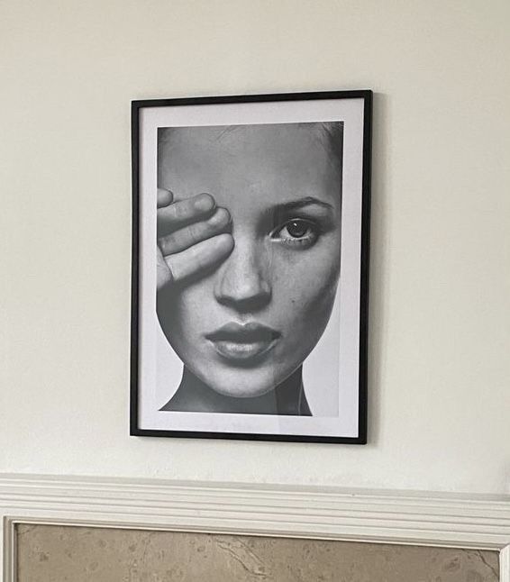 a black and white photo hanging on the wall above a fireplace