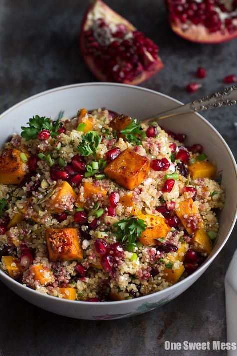 a white bowl filled with rice and pomegranate on top of a table