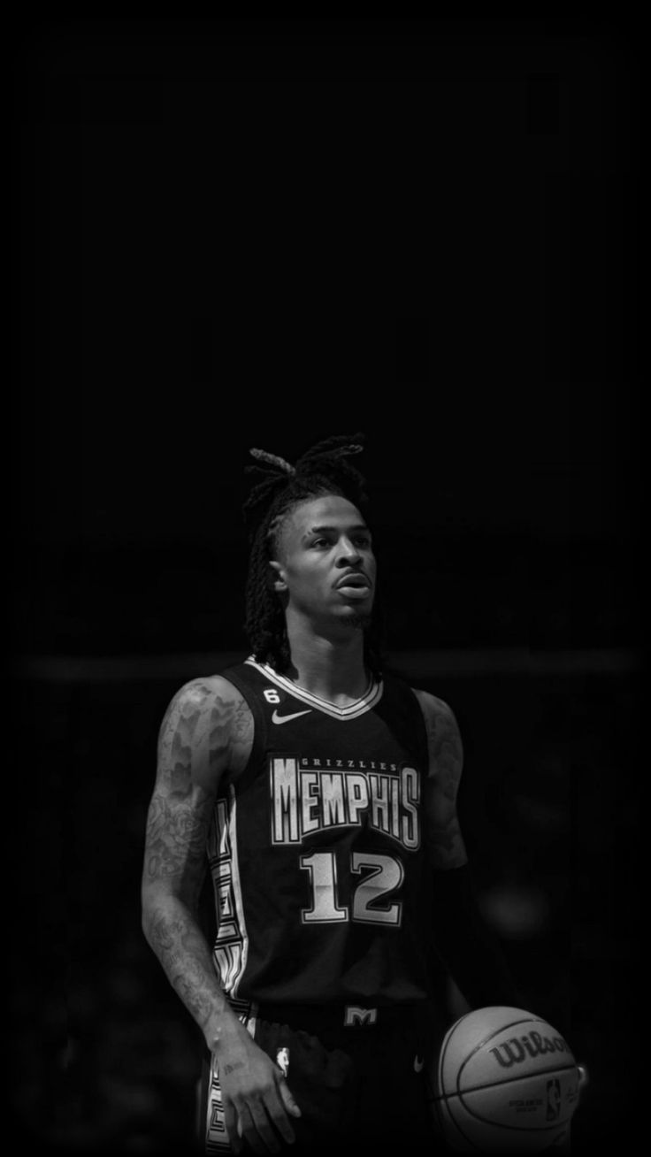 a basketball player with dreadlocks standing in front of a black and white photo