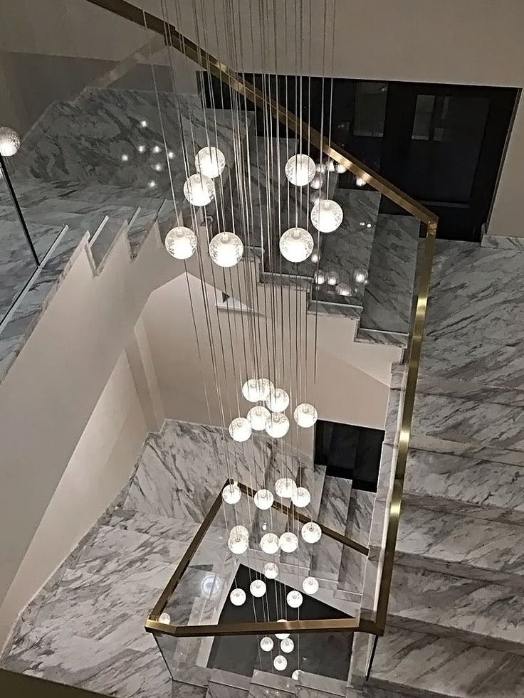 an elegant staircase with chandelier and marble flooring in a modern house or apartment