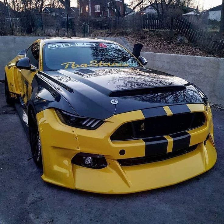 a yellow and black sports car parked in a parking lot