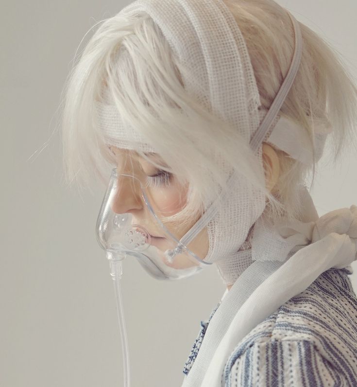 a woman with white hair wearing an oxygen mask