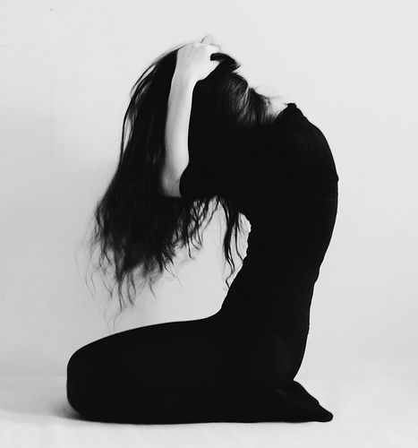 a woman with long hair sitting on the ground