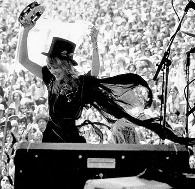 an old photo of a woman with a top hat at a concert