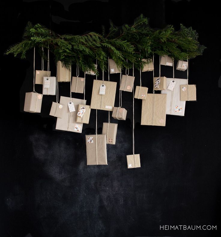 christmas presents are hung from the branches of a fir tree with tags attached to them