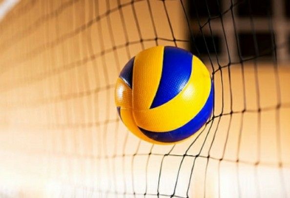 a yellow and blue volleyball sitting on top of a net