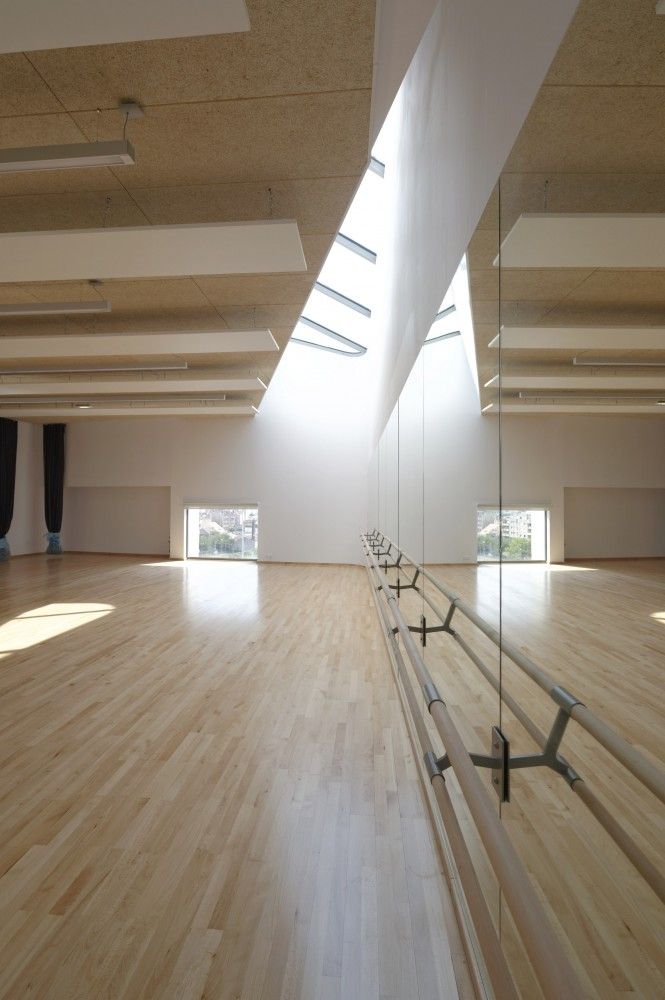 an empty room with wooden floors and skylights