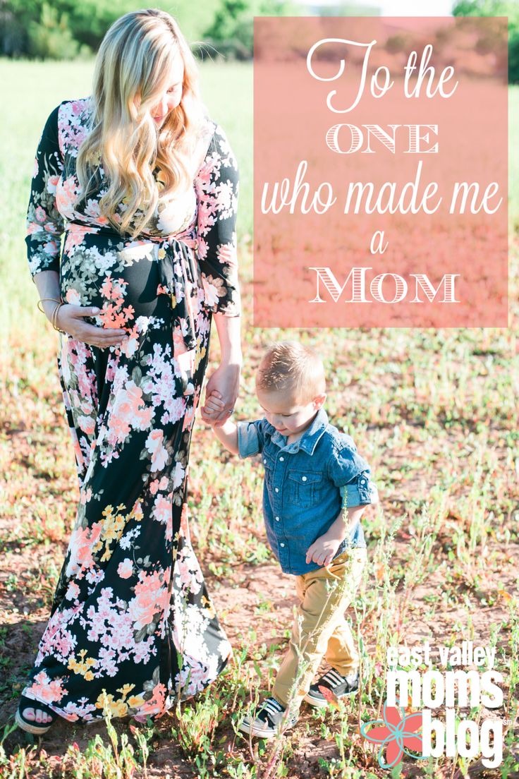 a mom holding her son's hand while standing in the grass