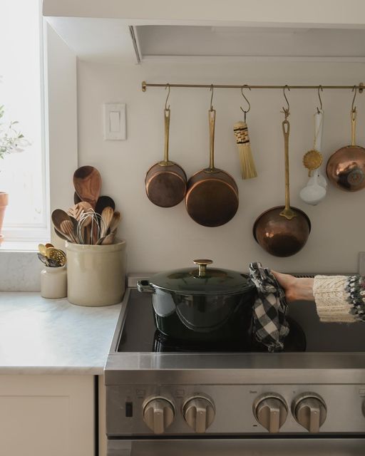 a kitchen with pots and pans hanging on the wall next to an open stove