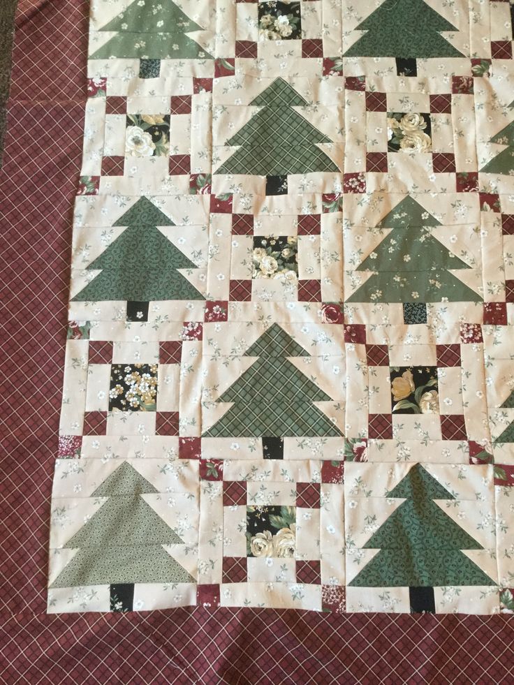 a quilted table runner with christmas trees on it