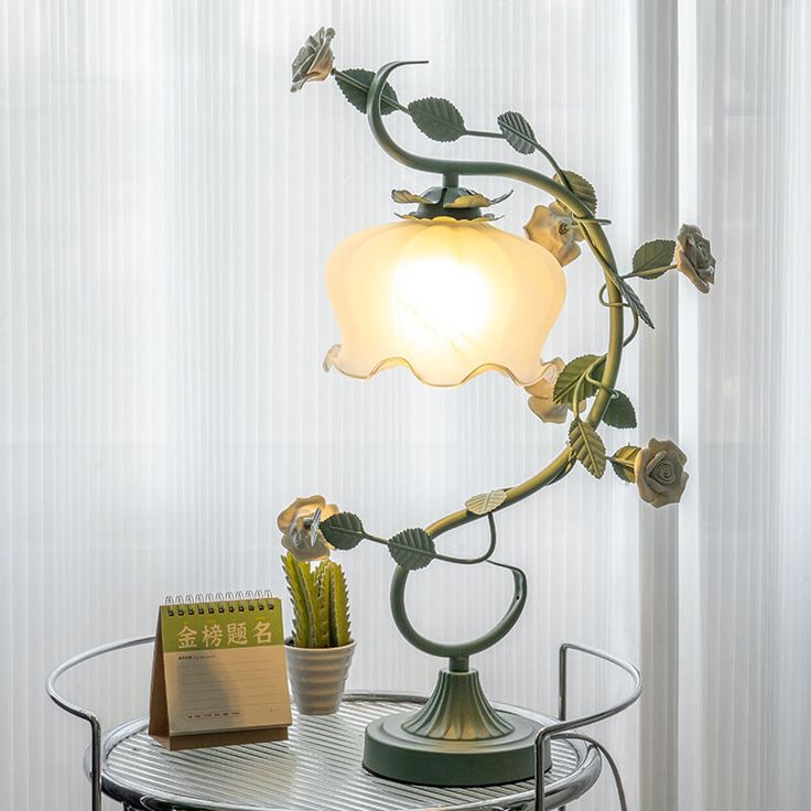 a lamp that is sitting on top of a table next to a potted plant