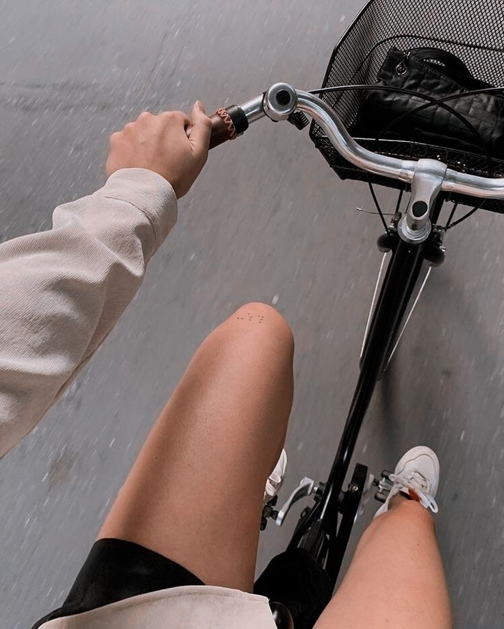 a person riding on the back of a bike with their legs in the front basket