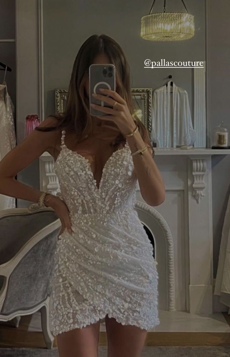 a woman taking a selfie in a white dress