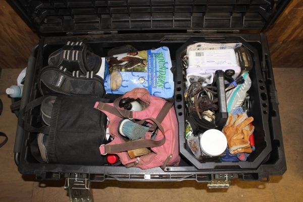 an open suitcase filled with various items on the floor