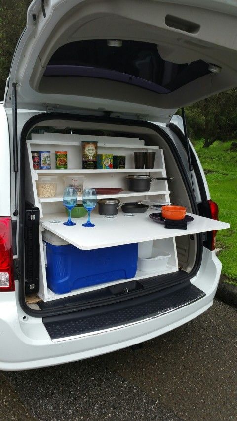 the back end of a white van filled with food and drinks