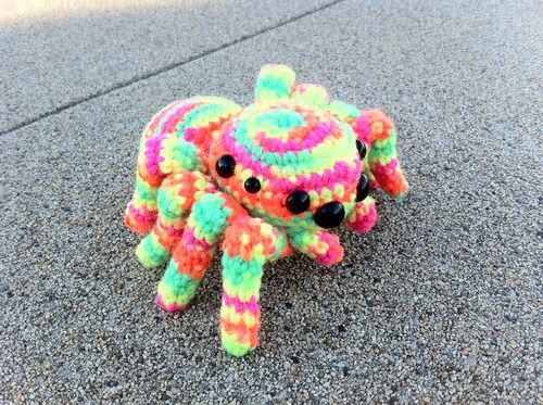 a multicolored stuffed animal sitting on the ground