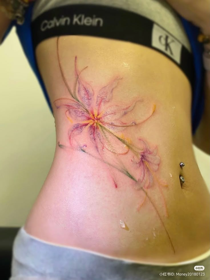 a woman's stomach with flowers painted on the side and under her tummy