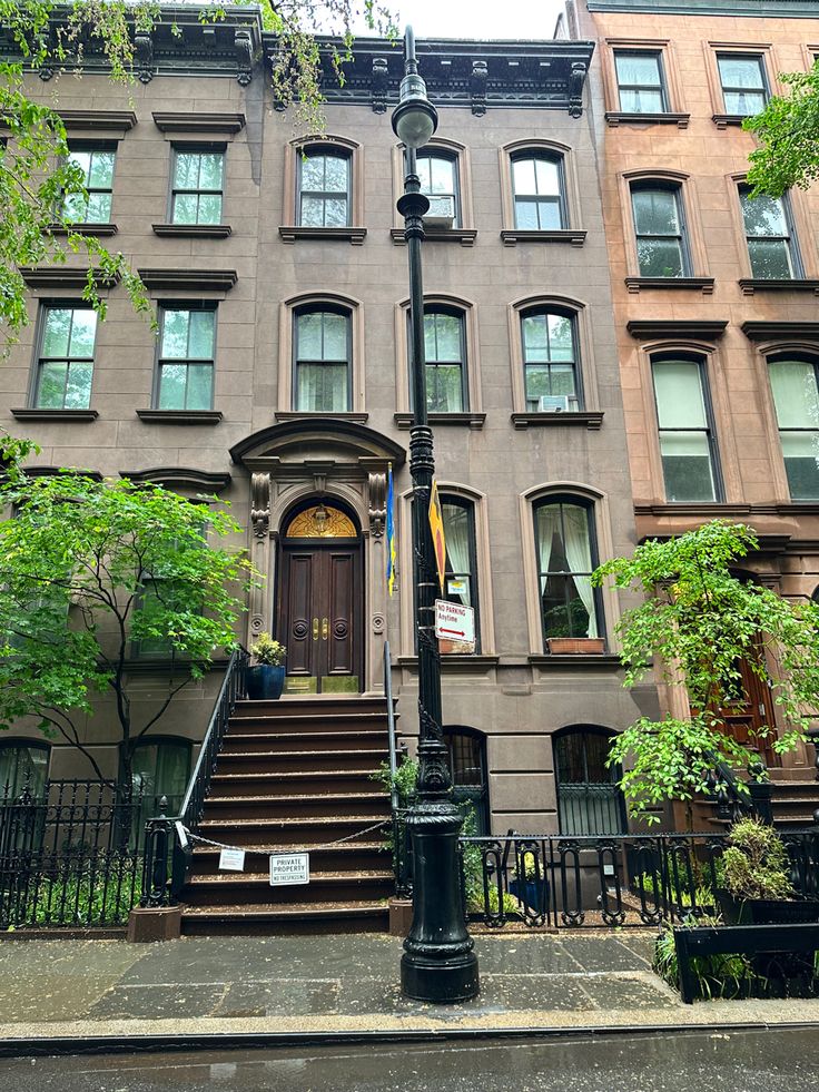 an apartment building with stairs leading up to the front door and second story windows on either side