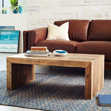 a living room scene with focus on the couch and coffee table in the foreground