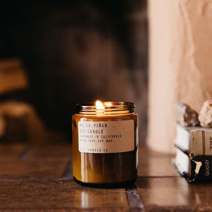 a candle sitting on top of a table next to a book