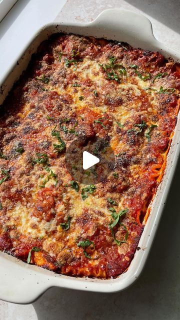 a casserole dish with meat and vegetables in it on a white table top