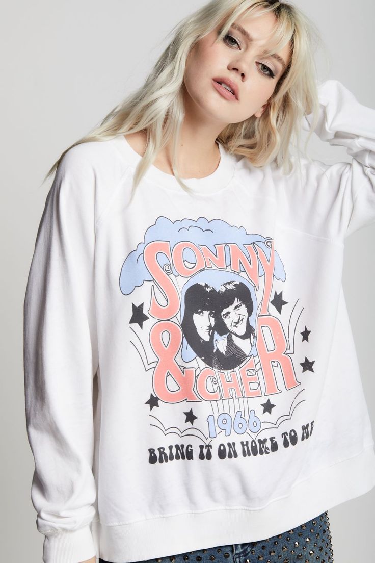 This sweatshirt is an absolute must have for any Sonny & Cher fan. The front features the duo's names and a photo graphic of the icons with their song "Bring It On Home To Me" below. "Sonny & Cher" is also featured on the back with stars. Made with vintage washed fabric, ribbed hems, a relaxed crew neckline, and an oversized fit. The design of this style is oversized. For a more standard fit, choose a size down. Details Style #302270 Color: White Sonny & Cher Bring It On Home To Me Oversized Swe Pop Culture Graphic Print Sweatshirt For Fall, Winter Concert Graphic Print Tops, Winter Graphic Print Tops For Concerts, Graphic Print Tops For Winter Concerts, Oversized Graphic Print Sweatshirt For Concerts, Graphic Print Sweatshirt For Fan Merchandise, Relaxed Fit Graphic Sweatshirt For Fan Merchandise, Retro Graphic Print Sweatshirt For Concerts, Relaxed Fit Graphic Print Sweatshirt For Fans