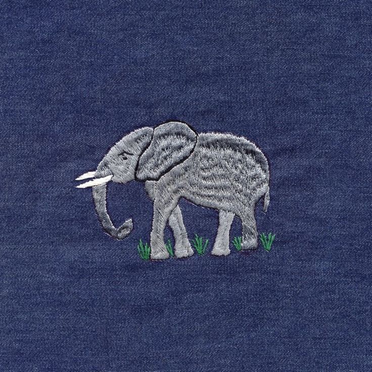 an elephant is embroidered on the back of a blue t - shirt with green grass