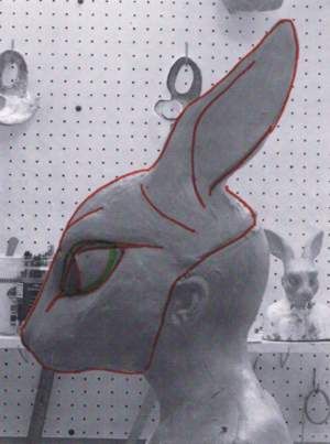 a sculpture of a rabbit with glasses on it's head in front of a wall