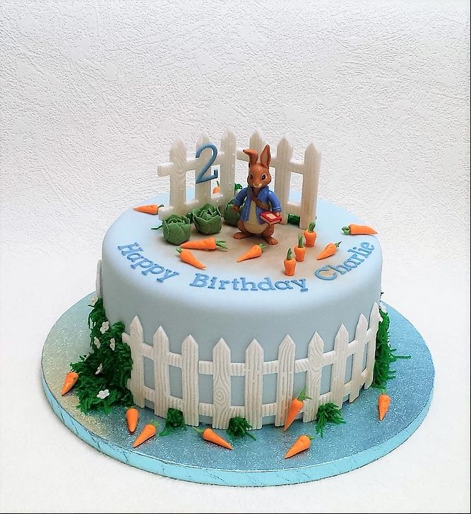 a birthday cake with carrots and a rabbit on top