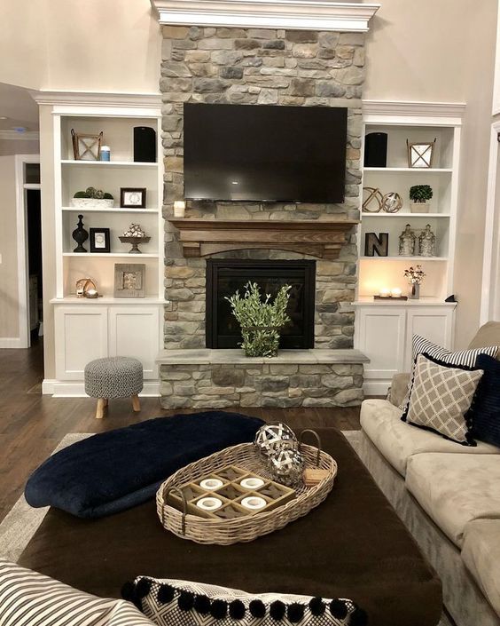 a living room filled with furniture and a flat screen tv mounted above a fire place