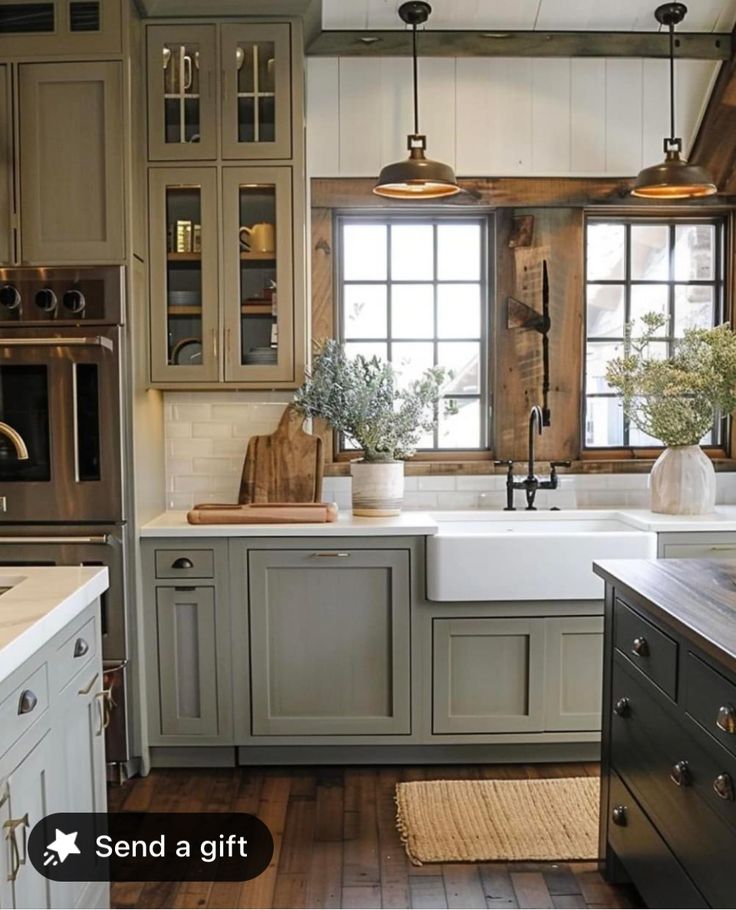 a kitchen with gray cabinets and white counter tops is shown in this image, there are lights hanging over the sink