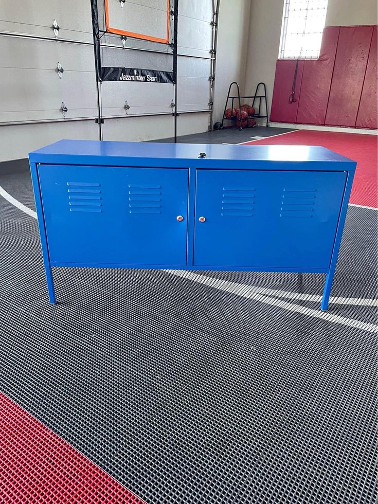 a blue locker sitting on top of a basketball court next to an empty basket ball hoop