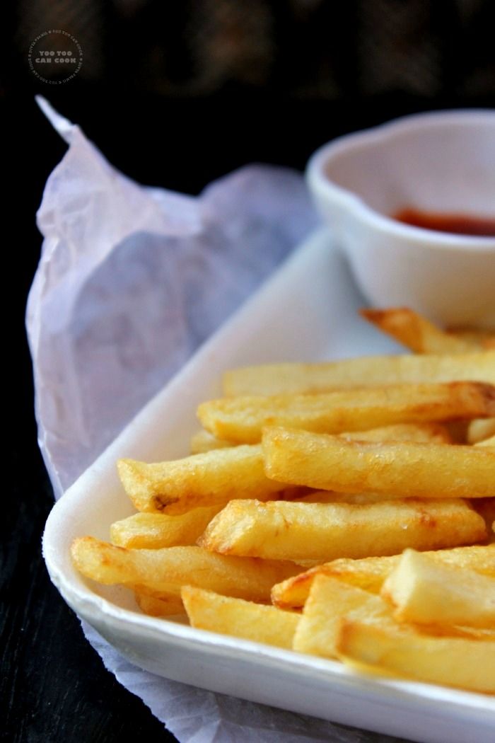 french fries on a white plate with ketchup in a bowl next to it