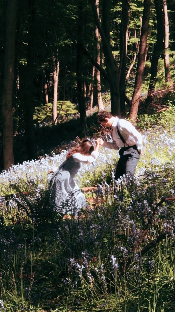 two people in the woods touching each other