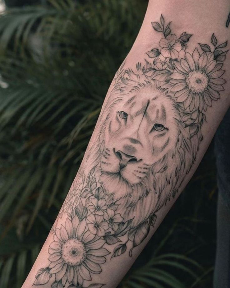 a lion and flowers tattoo on the arm