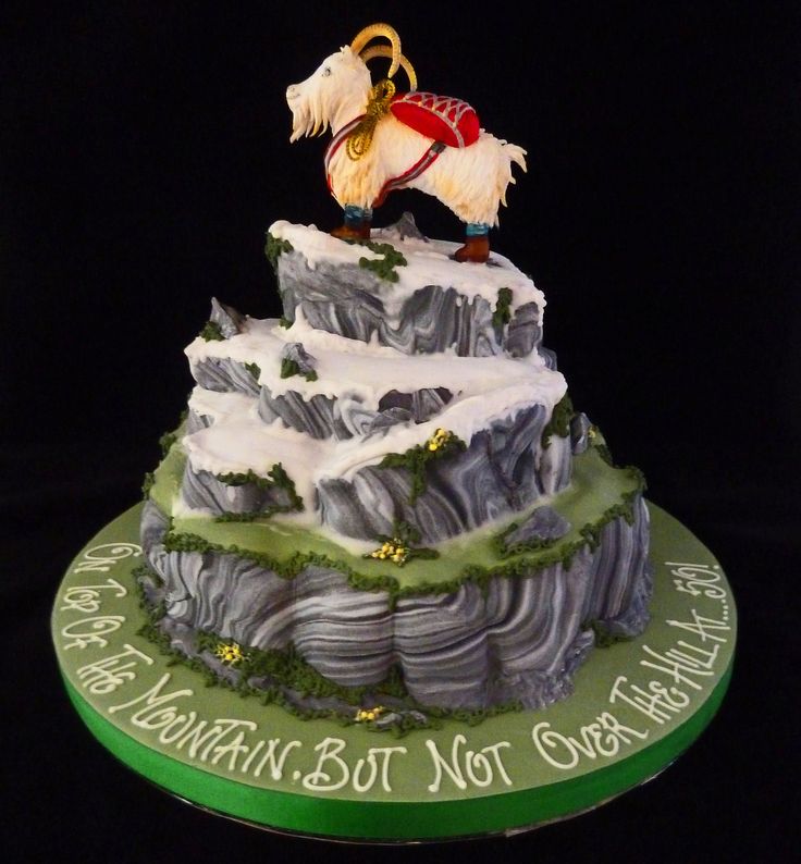 there is a cake that has a horse on top of the mountain with words written below it