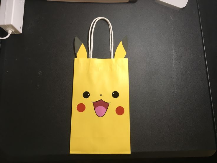 a yellow paper bag with a pikachu face on it sitting on a table