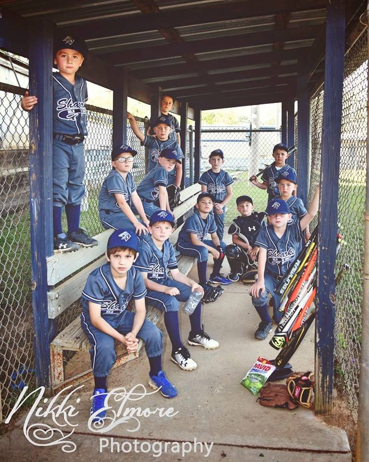 a group of young baseball players sitting in the dugout