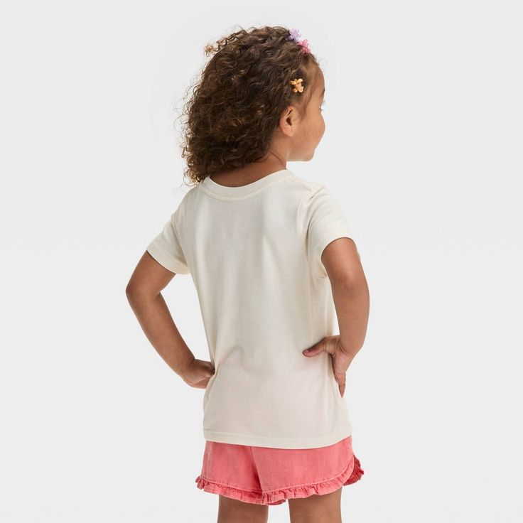 Fill your toddler's day with fun and excitement with this Short-Sleeve Rainbow Graphic T-Shirt from Cat & Jack™. Crafted from lightweight jersey fabric and featuring a tagless design, this short-sleeve T-shirt brings cool comfort to their day, while the below-waist length gives them the option of wearing it tucked in or untucked. Designed in a light beige hue, this crewneck tee features a rainbow graphic adorned with white flowers for cute style. Cat & Jack™: Designed for all children so you can Playful Summer T-shirt For Playdate, Playful Soft-washed Tops For Playtime, Soft-washed Crew Neck Tops For Playtime, Playtime Soft-washed White Tops, Soft-washed Cotton Tops For Playwear, Casual T-shirt For Playdate, White Cotton Top For Playdate, Playful Crew Neck Tops For Playdate, Cotton Short Sleeve T-shirt For Playdate