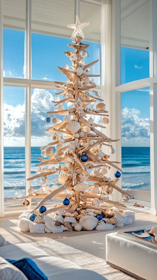 a christmas tree made out of seashells in front of a window with the ocean outside