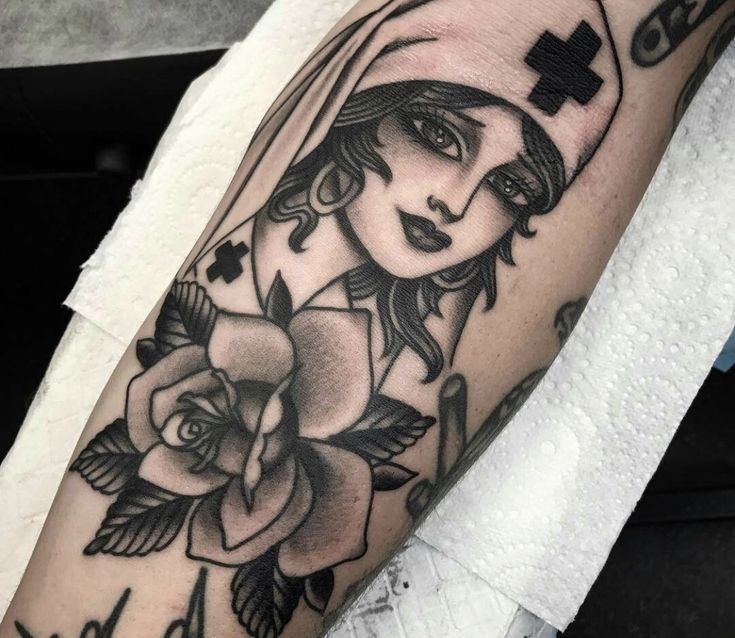 a woman's arm with a cross on it and roses in the corner,